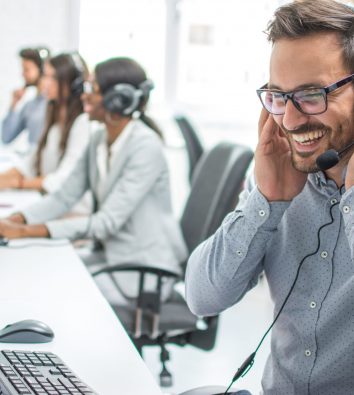 Smiling customer service executive with headset working in call
